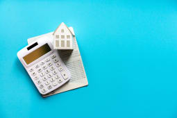 Une maison, des documents et une calculatrice