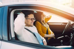 Deux jeunes ayant l'air effrays dans une voiture.