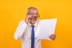 Un homme regarde attentivement un document.