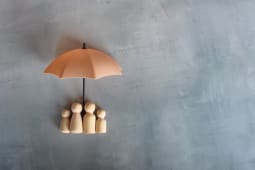 des figurines en bois sous un parapluie