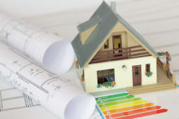 Une maison miniature avec des documents, notamment un DPE.