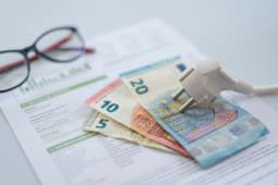 Un document et des billets entours d'un fil lectrique.