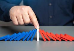 des dominos bleu et rouge tombent de chaque ct d'un domino blanc au centre.