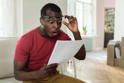 Un homme regarde un document l'air trs tonn.