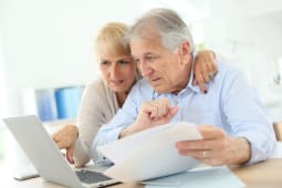 Un couple de seniors regarde des documents.