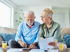 Deux personnes ges regardent un document.