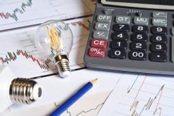 Une ampoule une calculatrice et des documents.