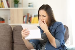 Une femme regarde un document l'air inquiet.