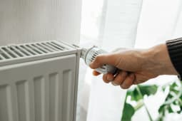 Quelqu'un tourne le thermostat d'un radiateur.
