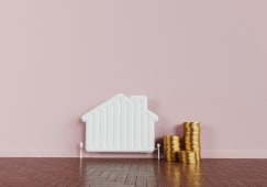 Un radiateur en forme de maison et des pices de monnaie.