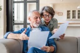 Un homme et une femme discutent en regardant des documents.