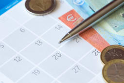 Un calendrier, des billets et des pices de monnaie.
