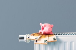 Des billets et une tirelire sur un radiateur.