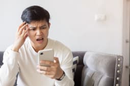 Un homme l'air effray regarde son tlphone