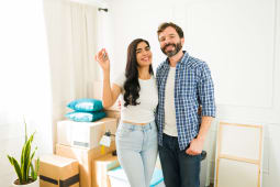 Un homme et une femme montrent des clefs dans un logement.