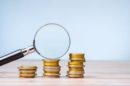 Une loupe et des pices de monnaie.