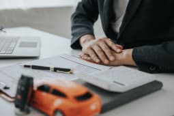 Une voiture miniature, une calculatrice et des documents.