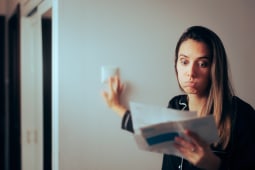 Une femme regarde un document l'air perplexe.