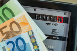 Un compteur de KWh et des billets.