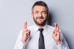 Un homme croise les doigts.