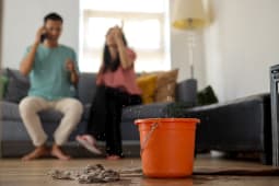 Un homme et une femme au tlphone aprs un dgts des eaux dans leur logement.