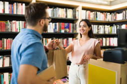 Une jeune femme achte des livres.