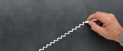 Quelqu'un trace un escalier sur un tableau.