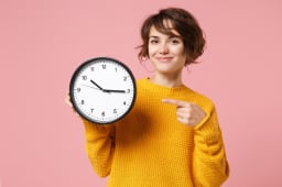 Une femme dsigne une horloge.