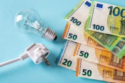 Des billets de banque, une prise et une ampoule.