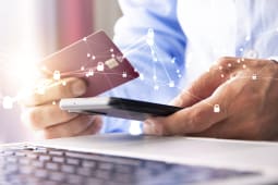 Une personne regarde une carte bancaire et son tlphone.