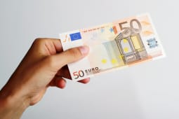 Quelqu'un tient un billet de 50 euros.