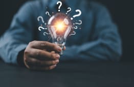 Une ampoule et des points d'interrogation.