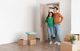 Un couple dans un logement avec des cartons.