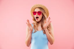 Une femme porte un chapeau et a un air surpris.