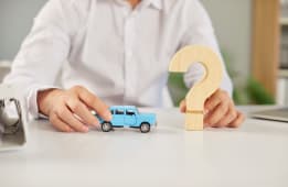 Quelqu'un tient une voiture miniature et un point d'interrogation.