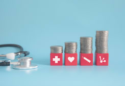 Des piles de pices de monnaie et un stthoscope.