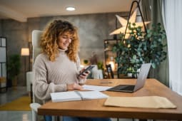 Une femme regarde son ordinateur.