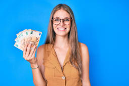 Une femme montre des billets de 50 euros.