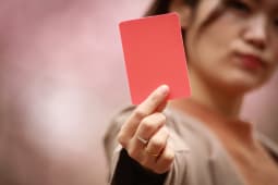 Une personne montre un carton rouge.