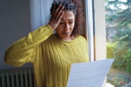 Une femme regarde un document avec inquitude.
