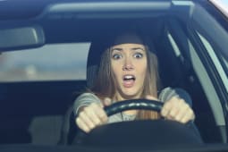 Une femme effraye dans une voiture.
