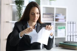 Une femme dchire un document.