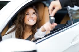 Une femme au volant d'une voiture.