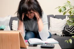 Une femme se prend la tte entre les mains.