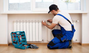 Un homme installe un thermostat sur un radiateur