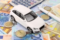 Une voiture miniature sur des billets.