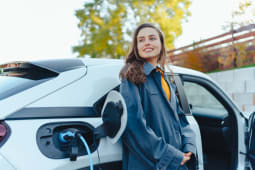 Jeune femme attendant que sa voiture lectrique se charge chez elle