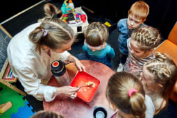 Une enseignante montre une exprience scientifique  des enfants.