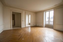Intrieur d'un appartement vide avec parquet et moulures dcoratives.