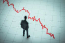 Homme observant une courbe descendante rouge sur graphique.